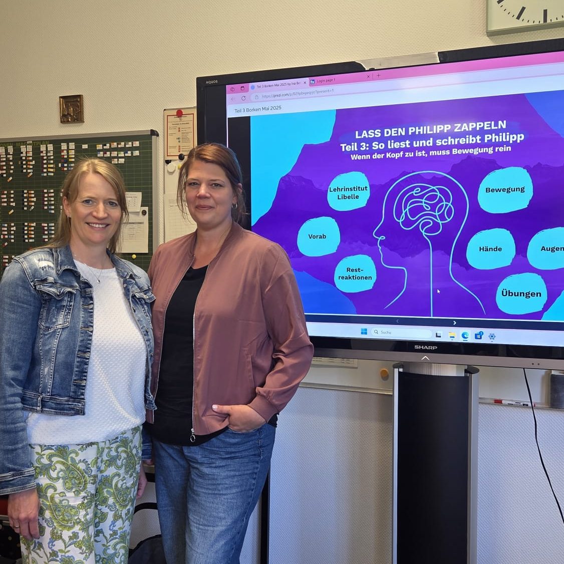 Ina und Meike stehen vor einem Bildschirm mit Informationen zu mentaler Gesundheit.